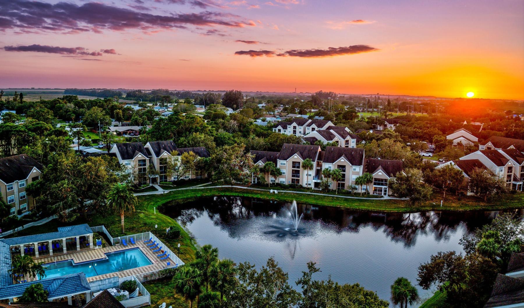 a body of water with houses along it and a sunset in the background