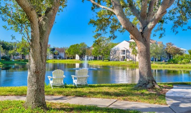 Find your perfect fit at Vista at Palma Sola a row of white chairs on a sidewalk by a lake