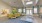 a large room with a rug and a table with plants on it